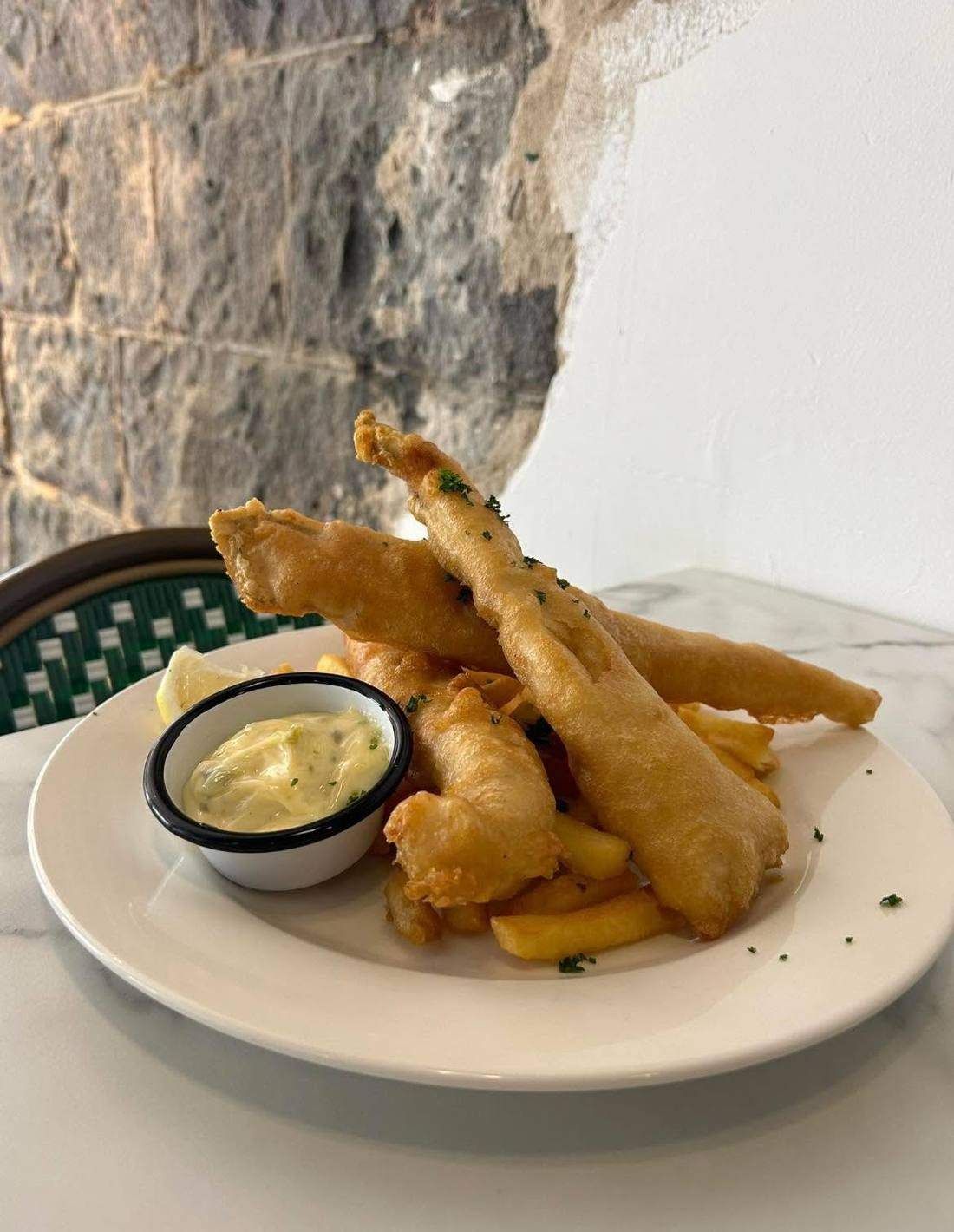 Beer-battered fish and chips with tartare sauce and lemon.
